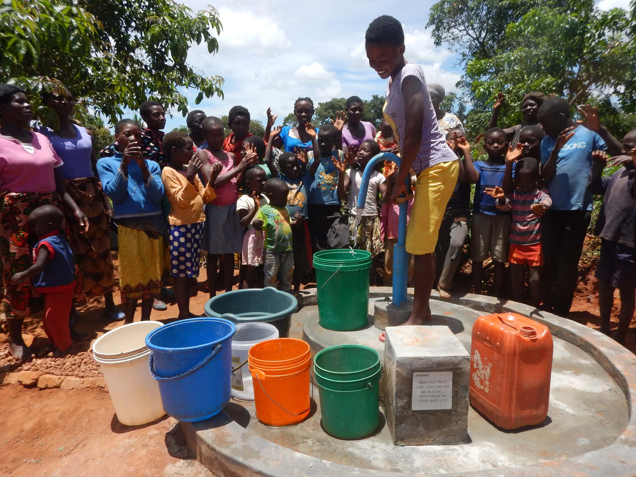 wells for zoe1 Clean water access in rural Africa, community gathers around a hand pump, highlighting efforts by FreeWater UK to promote sustainable water solutions and improved hygiene.
